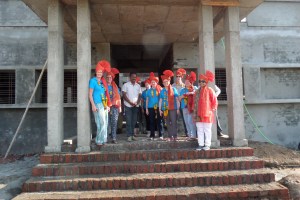  The team wearing traditional head gear at the front of the building.